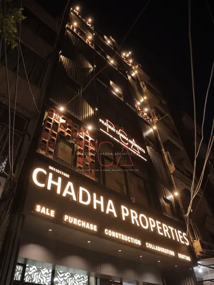 The facade of my firm's older real estate office, showcasing an elegant makeover with terracotta jaalis and ACP louvers. The illuminated signage and accent lighting create a distinguished presence at night, demonstrating my skill in commercial facade renovation.