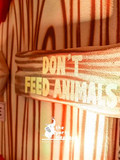 Fun, thematic details like this 'Don't Feed the Animals' sign add an authentic and playful touch to a jungle safari party.