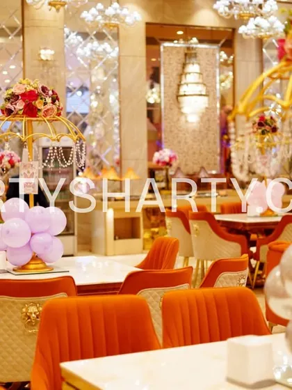 A close-up of the elegant table settings for a princess party, featuring ornate golden birdcage centerpieces with floral arrangements and coordinating balloon clusters.