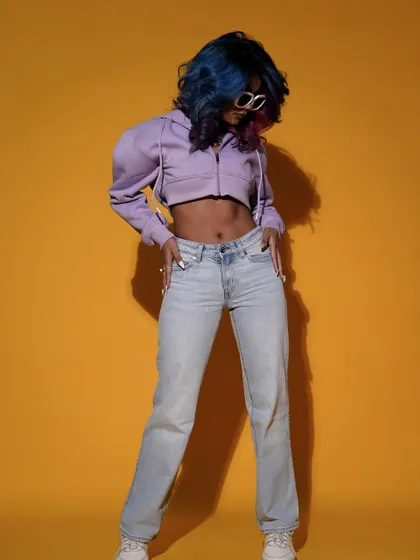 A full-length shot showcasing a casual, cool outfit against a bright yellow backdrop. The model's relaxed but confident pose perfectly captures the essence of modern, everyday style.