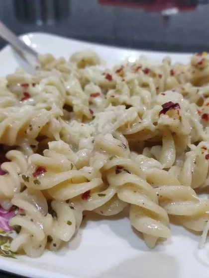 A close-up of the creamy texture and seasoning on my white sauce fusilli pasta.