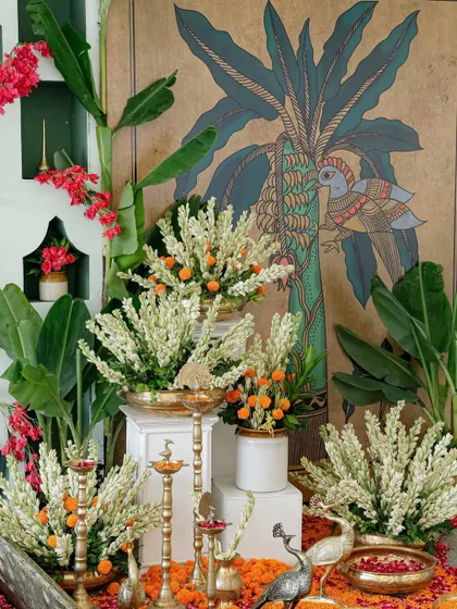 A stunning floral arrangement set against a hand-painted backdrop, blending South Indian art with traditional wedding flowers.