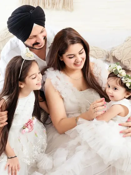 A picture of pure happiness. A family of four shares a candid, loving moment in our bright, boho-themed studio.