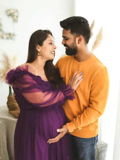 A beautiful, candid moment filled with love and laughter. The expecting couple shares a happy look in my bright and airy lifestyle studio setup.