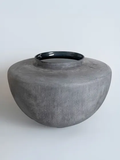 This wide-mouthed glass vase has a beautiful, slate-like texture and a glossy black rim. It is a substantial piece, perfect for holding a large floral arrangement or standing alone as a sculptural bowl.
