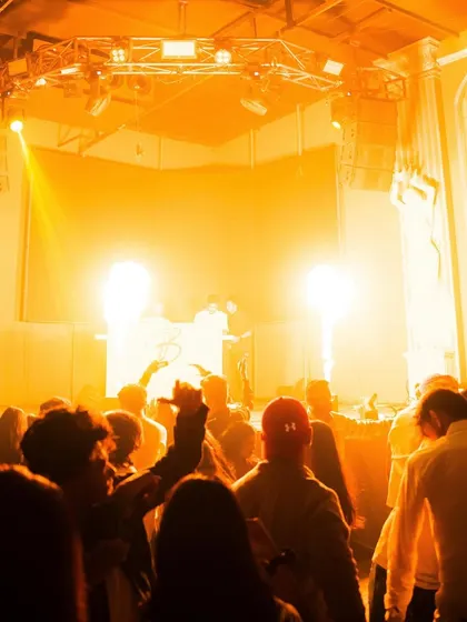 The whole club is bathed in a warm, intense orange light, creating a powerful and unified vibe.