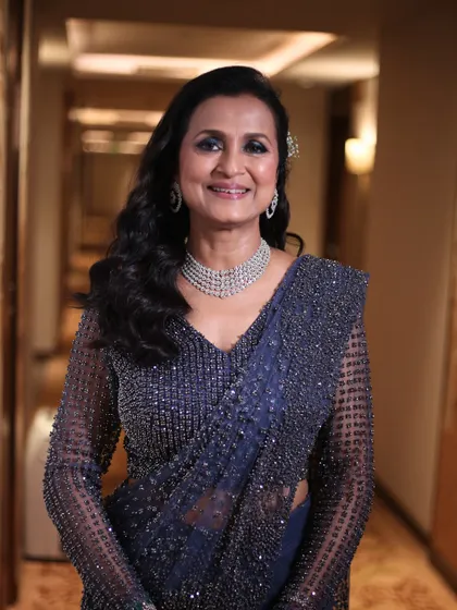 A smiling portrait that shows her confidence and joy. The makeup is glamorous yet sophisticated, perfect for a proud mother at a wedding.