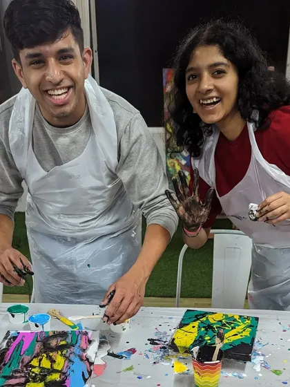 A couple having a blast at our splash painting event! It's a wonderfully messy and liberating experience where you can let go and create something truly unique.
