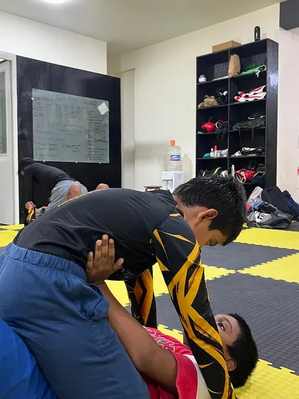 A young student practices his ground control. We teach kids the fundamentals of grappling in a safe and structured way.