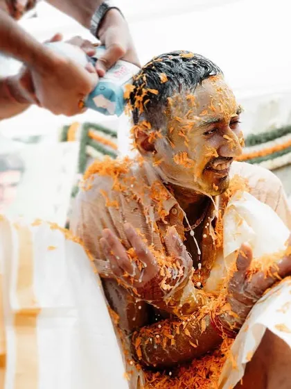A groom getting drenched with milk and turmeric during his Haldi. We capture the wild and fun side of wedding celebrations.
