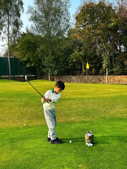 A junior golfer practices his swing on the chipping green. Our programs are designed to build strong fundamentals from a young age.