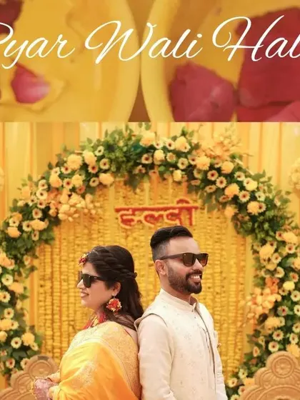 A beautiful shot of the couple posing back to back against their stunning marigold Haldi decor.