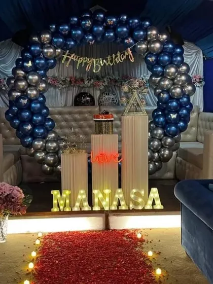 A duplicate of image 154, showing a blue and silver balloon arch in a lounge setting.