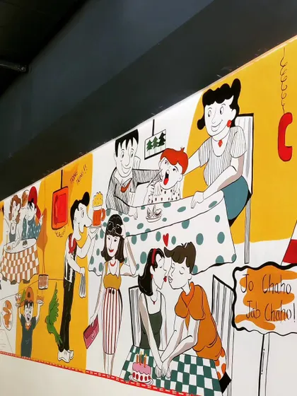 A close-up of the completed section of the diner mural, showing various scenes of people enjoying their time. The artwork is designed to be full of life and stories.