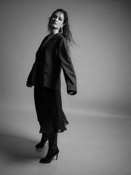 A black and white motion shot from 'FLOR', capturing the movement of the pleated skirt.