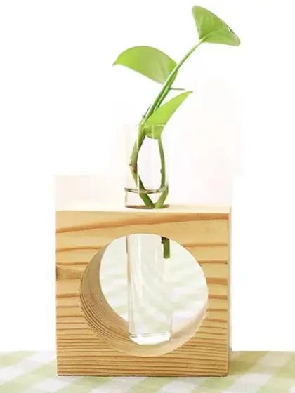 This single test tube planter features a glass tube set in a simple wooden block. It's a small, elegant piece perfect for propagating cuttings or displaying a single flower.