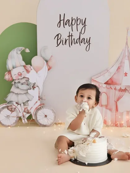 A taste of birthday fun. This shot captures the moment just before the real mess begins, with the birthday boy curiously tasting his cake. The simple, elegant setup with a circus tent background adds a touch of magic.
