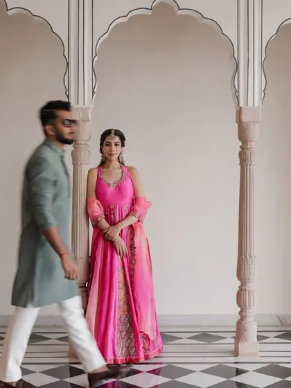 A creative shot with motion blur as the groom walks past the bride in a palace corridor.