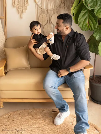 A father and son share a moment in a cozy corner of the studio. The dad's happy expression as he holds his son is a testament to a father's love.