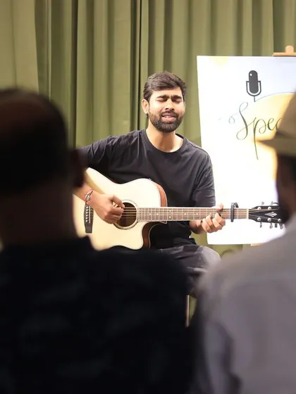 A musician serenades the audience at a "Speaking Souls" open mic.
