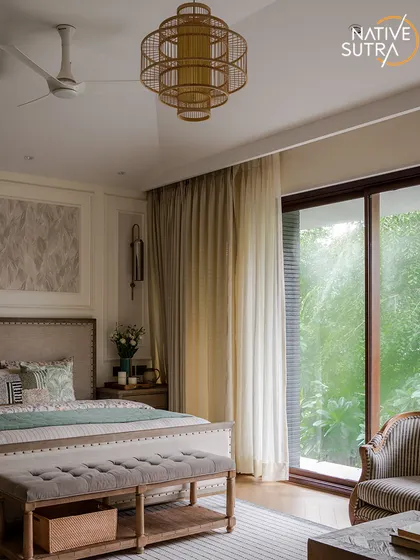 This wide view of the master bedroom showcases its perfect symmetry and connection to nature. The large sliding glass door floods the room with light, while the rattan chandelier adds a touch of organic elegance.