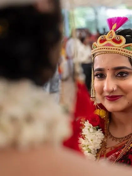 An over-the-shoulder shot capturing the bride's loving gaze towards her groom during the wedding ceremony.