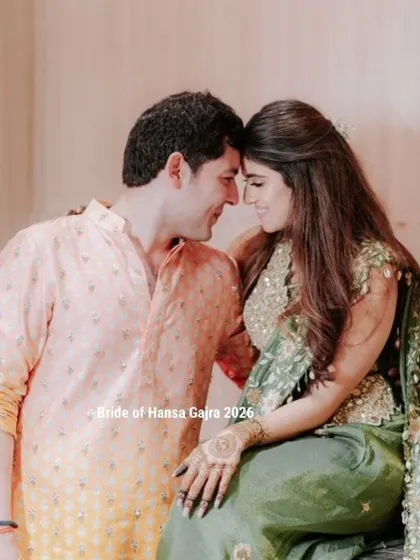 A romantic moment between a couple during their mehendi ceremony. The bride's minimal mehendi looks elegant against her green outfit as she shares a quiet moment with her partner.