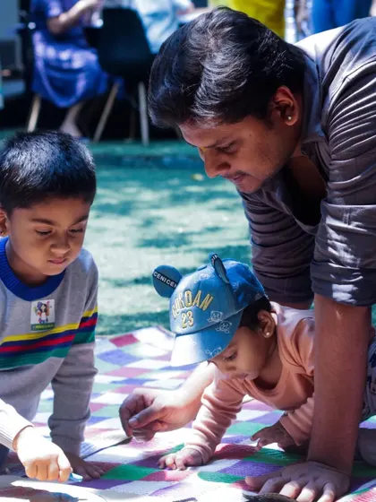 A father helps his little ones with their craft project during our Father's Day playdate. These hands-on activities are a wonderful way for families to connect and have fun.