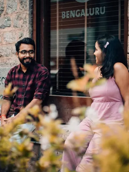 A candid shot of a couple near a window with "Bengaluru" written on it, grounding their story in the city where it unfolds.