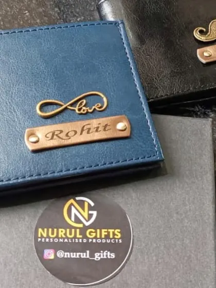 Two beautifully crafted personalized wallets, one in blue with an infinity 'Love' charm and the other in black with a mustache charm, both packed in my signature gift box.