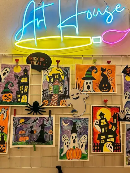 My Halloween art wall at the studio, showcasing a collection of spooky and fun paintings created in my online classes. Trick or treat.