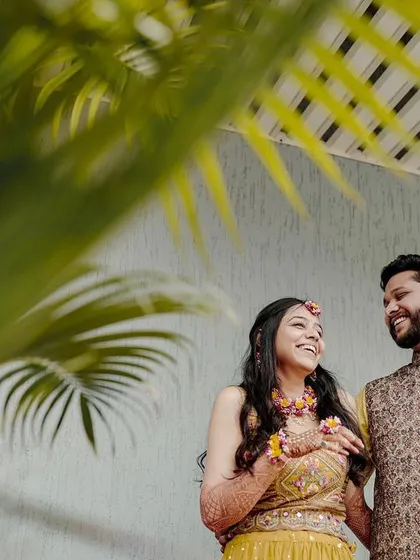 A candid shot of the couple during their Haldi ceremony, sharing a laugh and enjoying the moment.