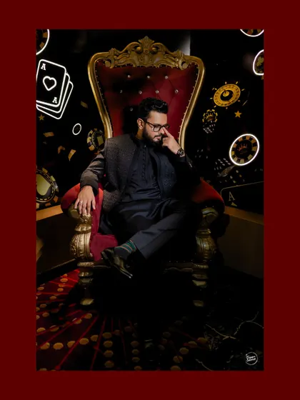 A stylish portrait of the groom, looking thoughtful and dapper in the casino-themed setting.