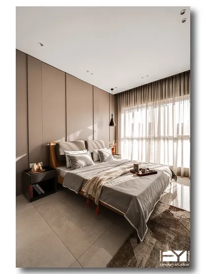A spacious and serene bedroom with a neutral color palette and a floor-to-ceiling panelled wall. The natural light from the large window creates a bright and airy feel, making the room a perfect modern retreat.