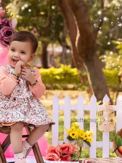 A joyful, candid shot of a little girl laughing during her sunny outdoor tent photoshoot.