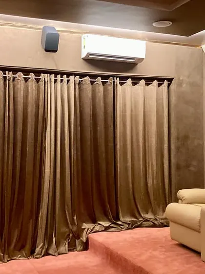 This image shows the side view of the Firozabad theater, highlighting the tiered seating platform, heavy curtains for light control, and the placement of surround speakers.
