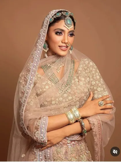 A close-up of a model with a sleek bridal bun, adorned with a statement matha patti and sheeshphool. This demonstrates my skill in creating hairstyles for campaign and editorial shoots.