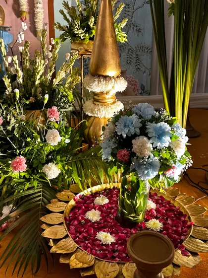 Another detail of the spiritual event decor, showing the mix of fresh flowers, brass elements, and floating petals.