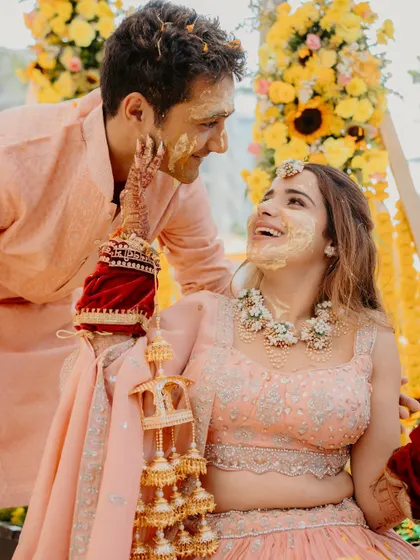 A candid moment of the bride playfully applying Haldi to the groom. These unposed interactions make for the most memorable pre-wedding photos.