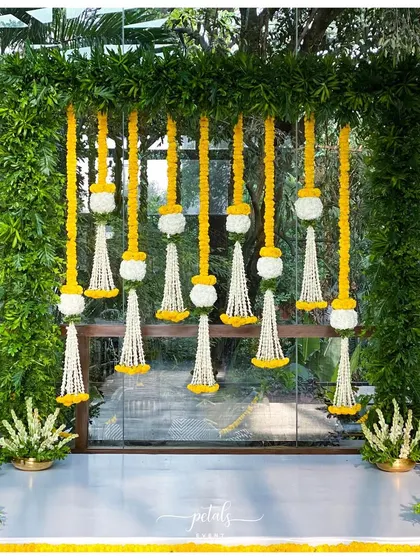This engagement decor features a stunning fern frame adorned with traditional floral streamers. The combination of green and yellow creates a fresh and vibrant look.