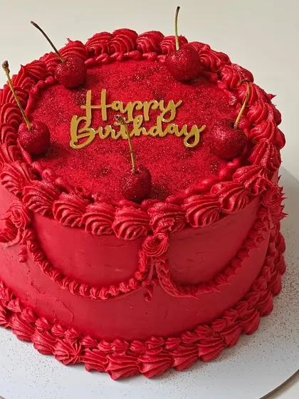A bold and beautiful vintage-style cake in a striking red color. The intricate piping and glittery cherries make this a simple yet glamorous choice.