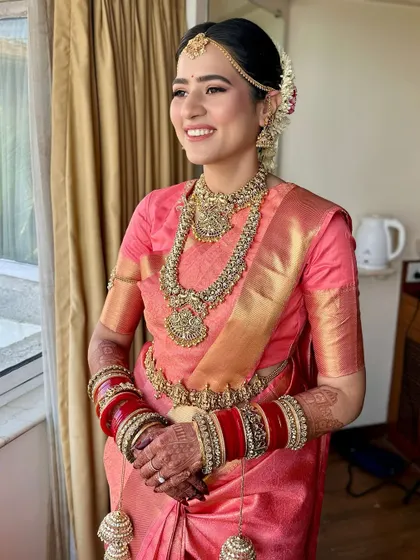 South Indian glory in all her grace. This look, with its soft peach saree and classic temple jewellery, is the definition of timeless elegance and a tribute to the radiant South Indian bride.