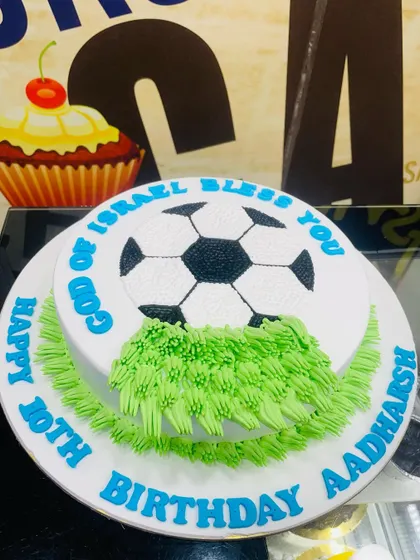 A simple 2kg football cake with a soccer ball design piped on top.