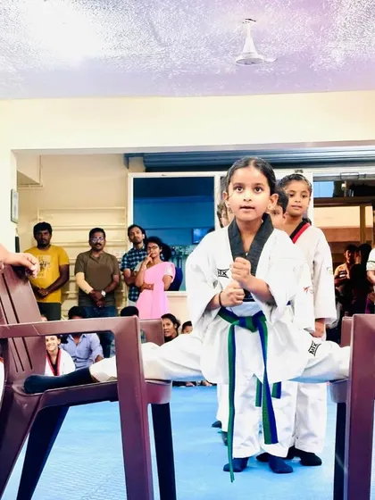 A young girl confidently holds a chair split.