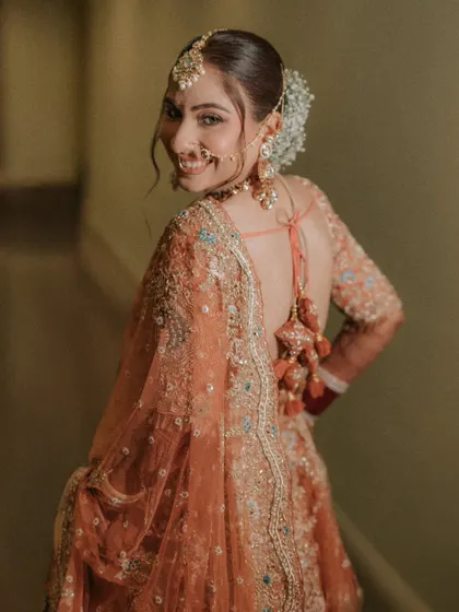 A smile that lights up the room. This over-the-shoulder shot of Muskan captures her happy and radiant personality, along with the beautiful back details of her bridal blouse.
