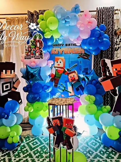 I brought the world of Minecraft to life for a 6th birthday party with this fully themed decoration. The setup includes a custom printed backdrop, character cutouts of Steve and Alex, and balloon pillars in the game's signature green, blue, and brown colors.