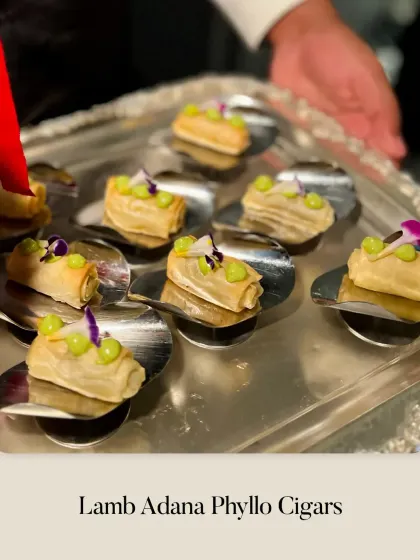 A tray of Lamb Adana Phyllo Cigars being served. These savory bites are inspired by Turkish flavors and are always a crowd-pleaser.