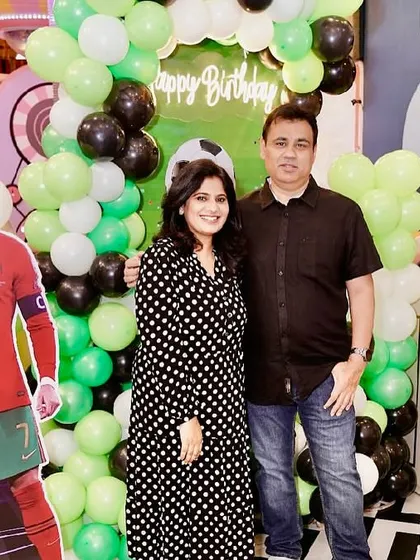 A football-themed birthday party setup, complete with green and black balloons and cutouts of famous football players.