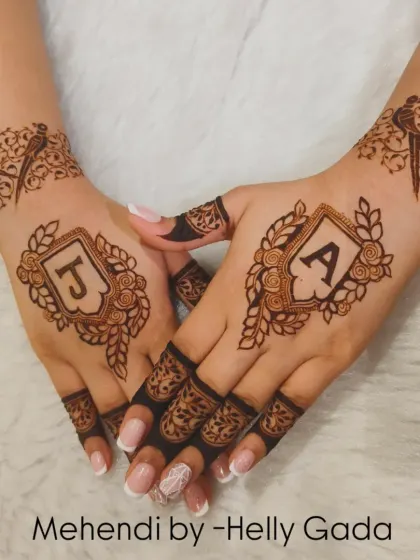 A beautiful and classic way to celebrate a union. This design features the couple's initials, J and A, each enclosed in an elegant, leafy crest on the back of the hands for a symmetrical and romantic look.