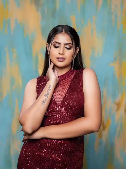 A beautiful shot showcasing the tattoo and the elegant drape of the maroon dress.